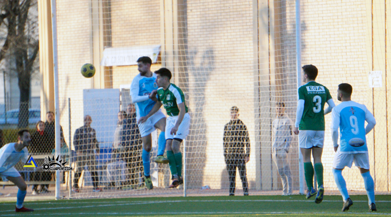 Cristian Ojeda, del Écija CF, se eleva ante la posición de un jugador del CD Arahal Balompié